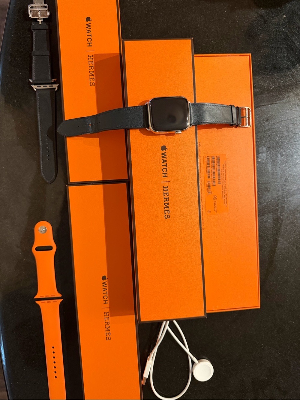 Apple Watch with Black Leather Hermès Strap and Bright Orange Sport Band